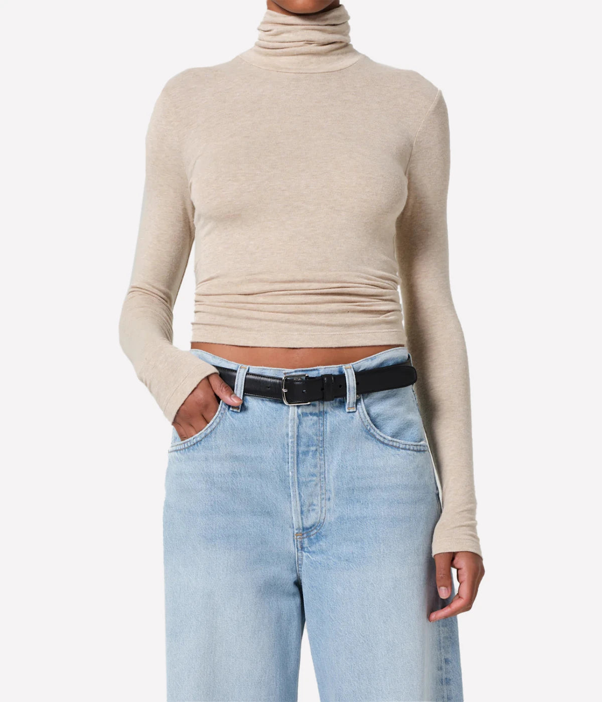ALT Text: Caradene Turtleneck in Heathered Almond, featuring a soft, light brown hue and a classic turtleneck design, displayed on a hanger.