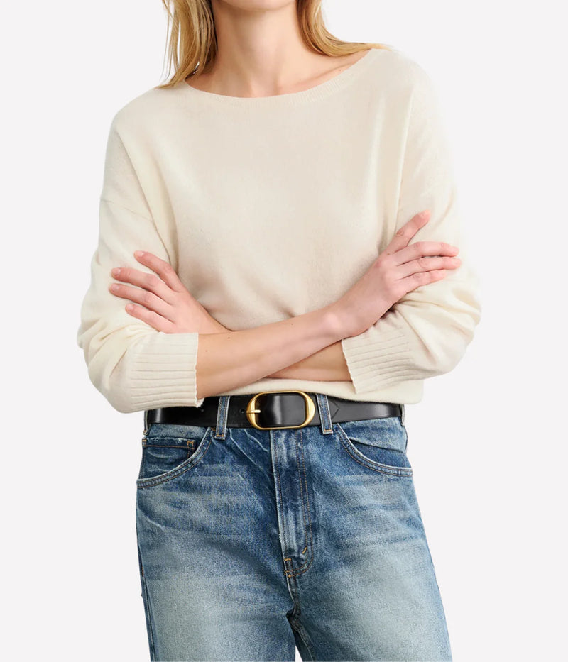 Person wearing a beige sweater and blue jeans with a white background. Nili Lotan Sweater