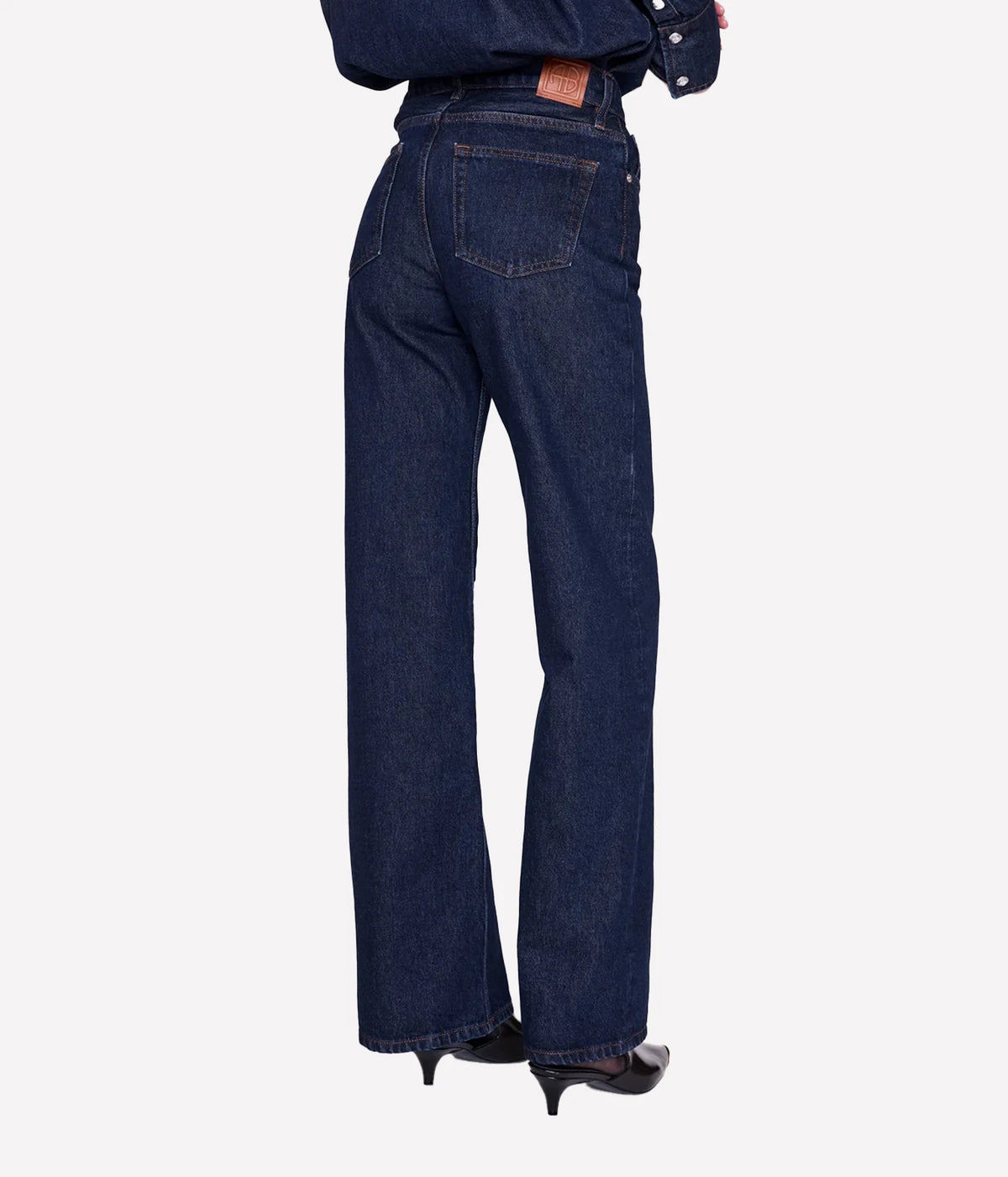 Back view of model wearing the Anine Bing Hugh Jean in Unwashed Blue with rear patch pockets and wide legs.