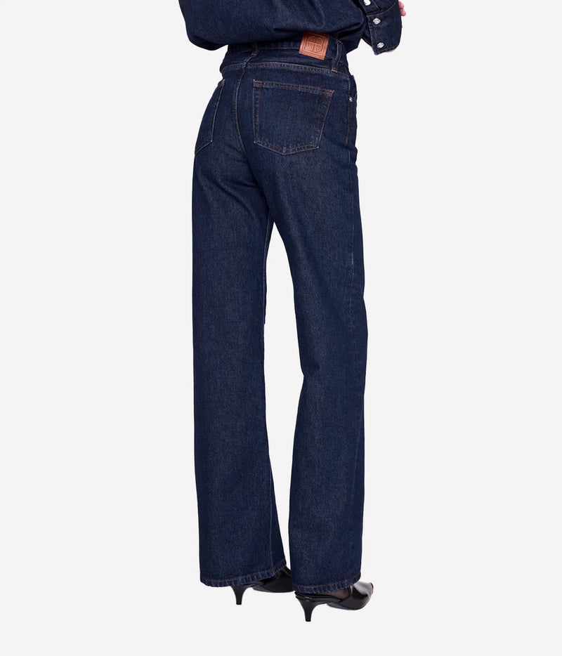 Back view of model wearing the Anine Bing Hugh Jean in Unwashed Blue with rear patch pockets and wide legs.
