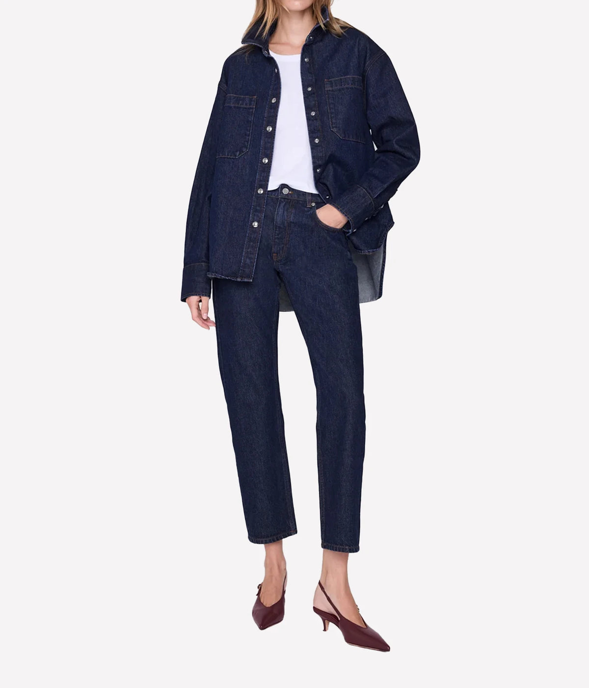 Model wearing the Anine Bing Samy Shirt in Unwashed Blue with matching dark denim jeans, front view.