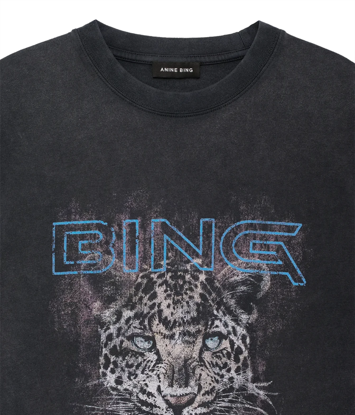 A close-up of a dark gray crewneck t-shirt featuring a distressed graphic of a leopard's face and the word 'BING' in blue outline lettering across the chest. The brand name 'ANNE BING' is visible on the inner neck label.