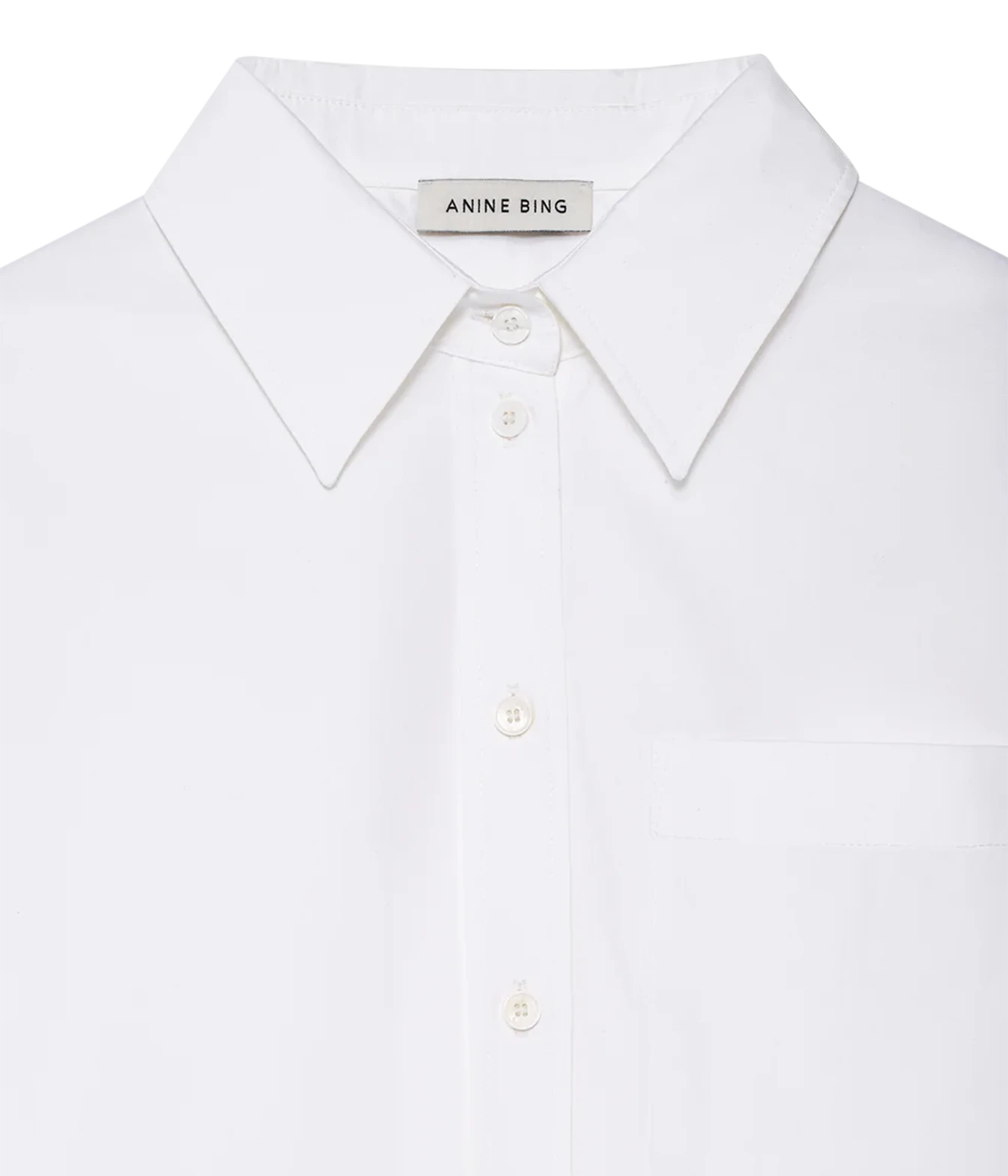 Close-up of a white Anine Bing button-down shirt with a classic pointed collar and matching buttons, set against a clean white background.