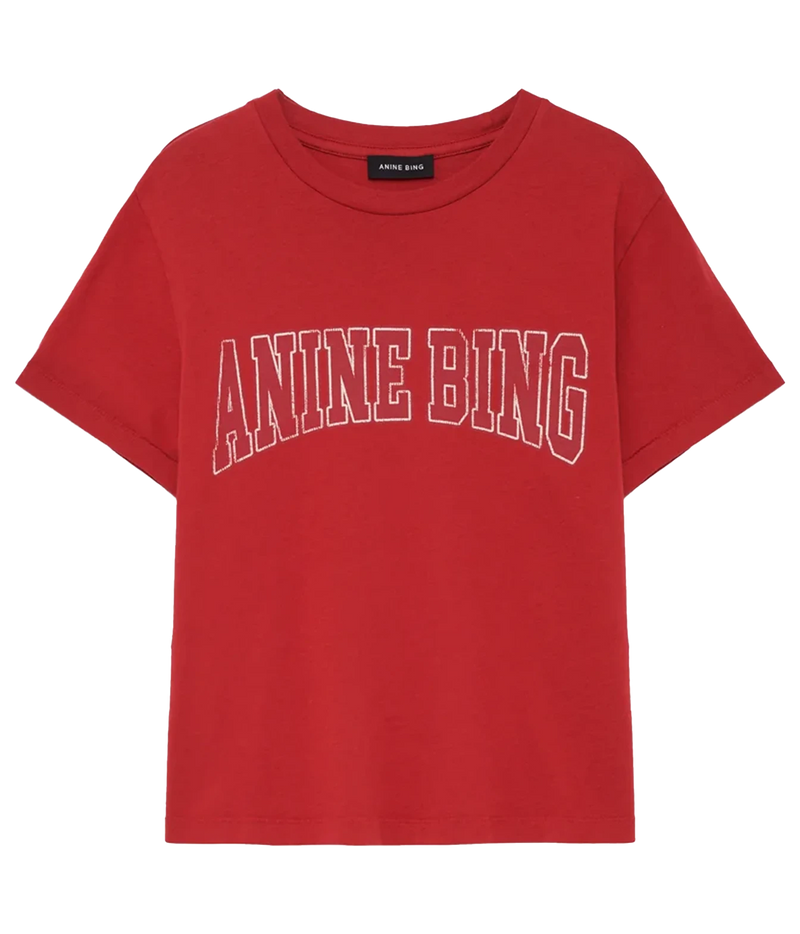 A red short-sleeve crewneck t-shirt featuring the text 'ANINE BING' printed in white arched block letters across the chest, shown against a plain white background.
