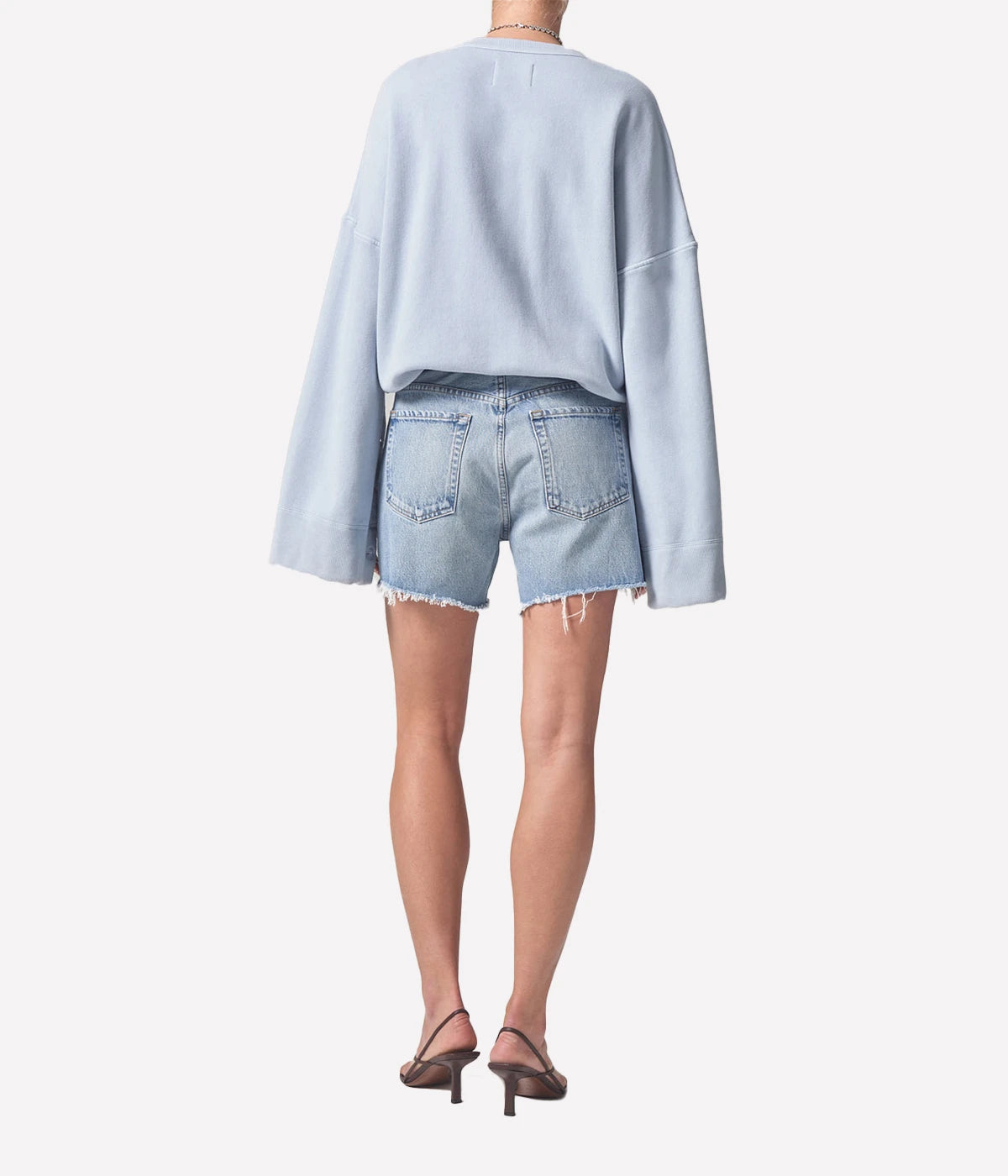 Relaxed-fit vintage-inspired denim shorts with distressed hems, styled with a linen button-up shirt and slides for an effortless summer look.