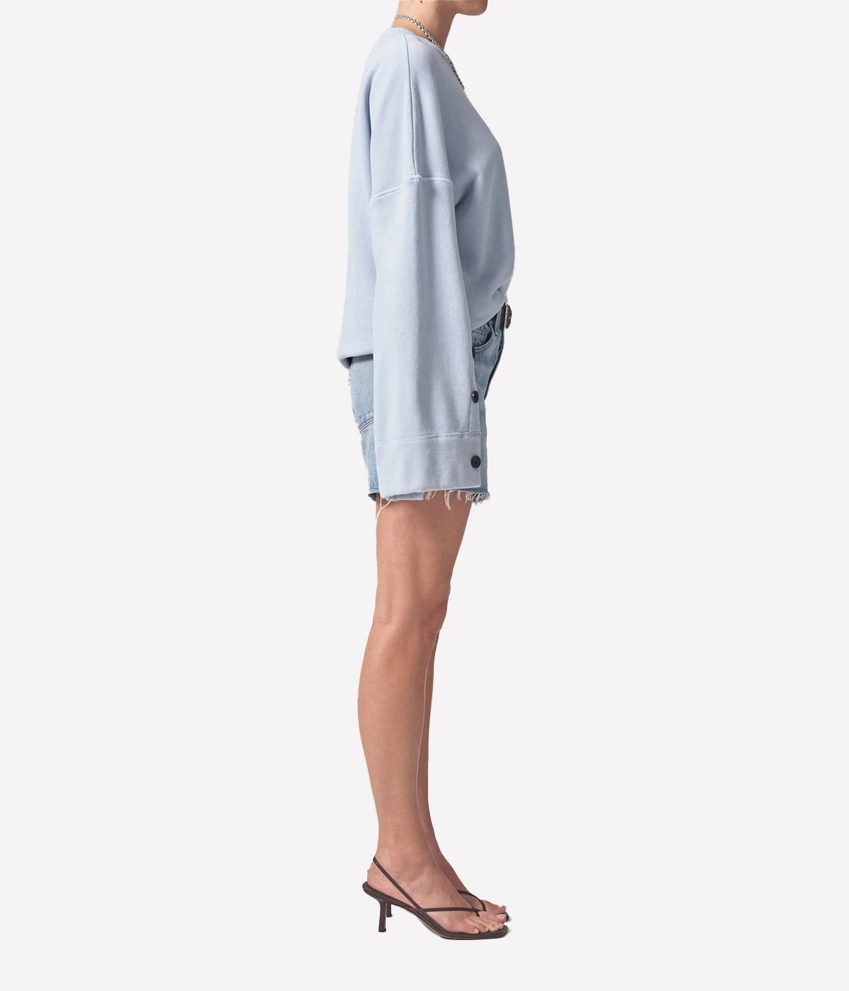 Relaxed-fit vintage-inspired denim shorts with distressed hems, styled with a linen button-up shirt and slides for an effortless summer look.