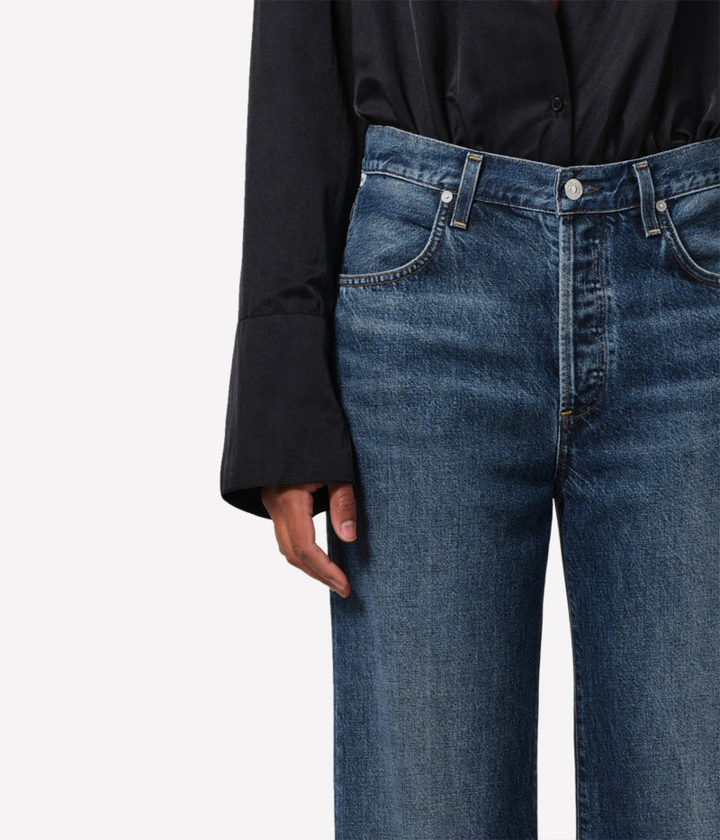 Neutral-toned high-rise cropped straight-leg jeans styled with a blouse and boots for a casual, yet polished look.