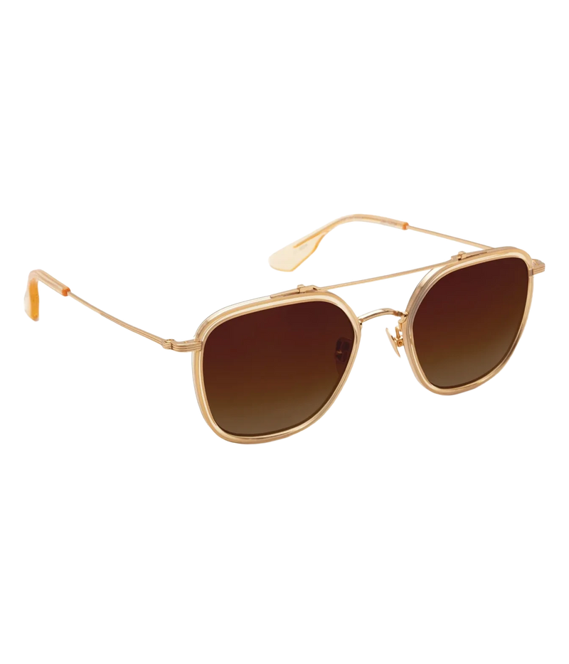 Three-quarter view of the KREWE Austin Sunglasses in 18K Titanium Champagne, showing the gold brow bar and slim temples