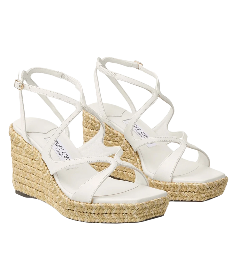 A pair of white strappy wedge sandals with woven jute espadrille soles, shown on a plain white background.