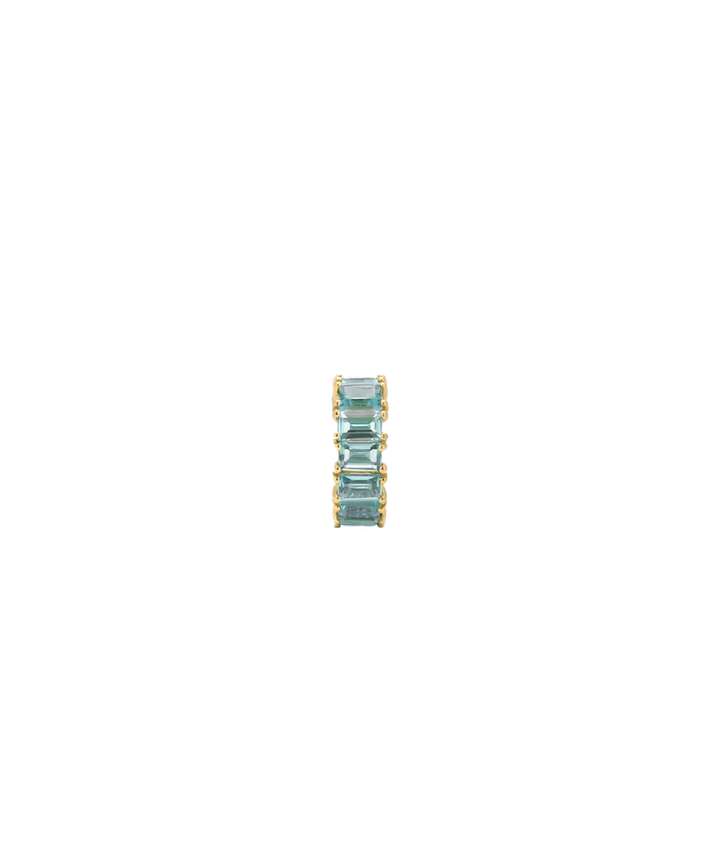 A slim gold-plated ring featuring a vertical stack of four rectangular-cut light blue gemstones, centered on a plain white background.
