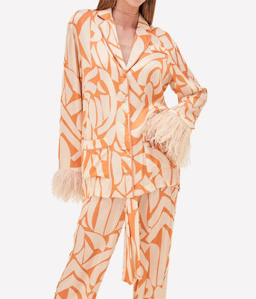 A pajama style button up shirt by Alexis. Cut from orange abstract print viscouse, take loungewear glam to the next level with this ostrich feather detailed garment.