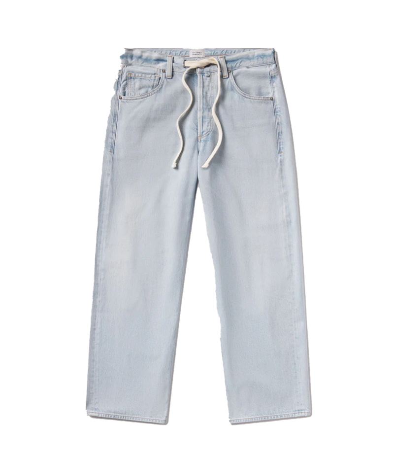 Woman wearing light indigo denim drawstring trousers with soft fading and relaxed fit, made from regenerative cotton. Brisbane, James Street. Shopping. Denim 