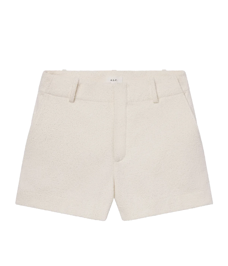 ALT text: A pearl-white tweed short with a high waist, cuffed hem, and discreet side pockets, styled in a soft Italian cotton blend.