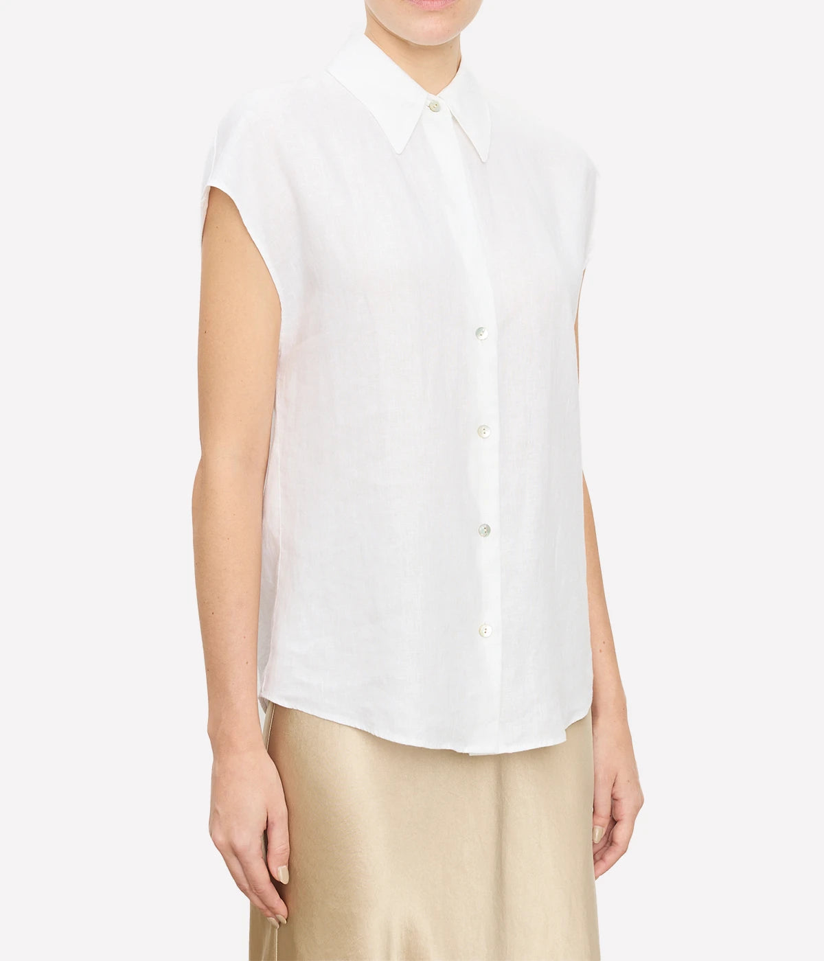 Relaxed linen blouse with cap sleeves, styled with tailored trousers for a polished look.