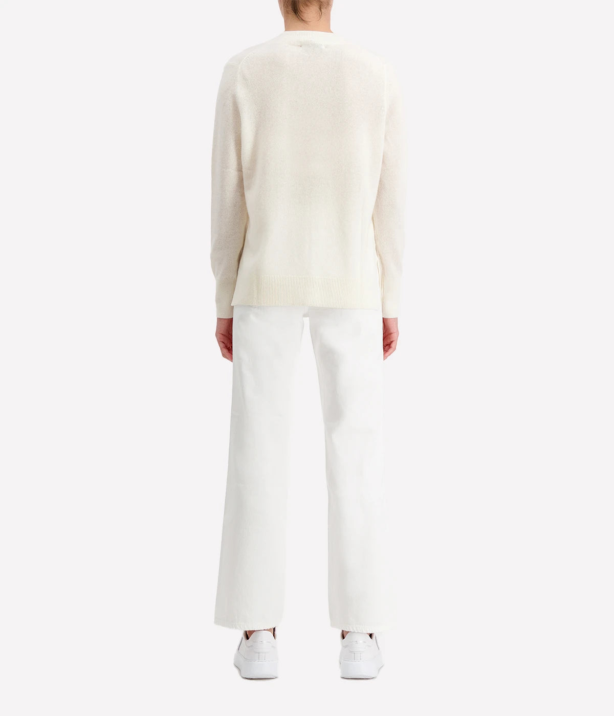 Luxurious cashmere V-neck sweater in leaf heather, styled with jeans and boots for a cosy yet refined look.