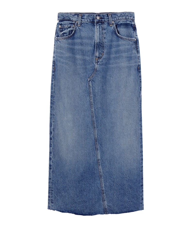 Full-length denim skirt with a raw hem and back slit detail, styled with a white tee and blazer for a modern, polished look.