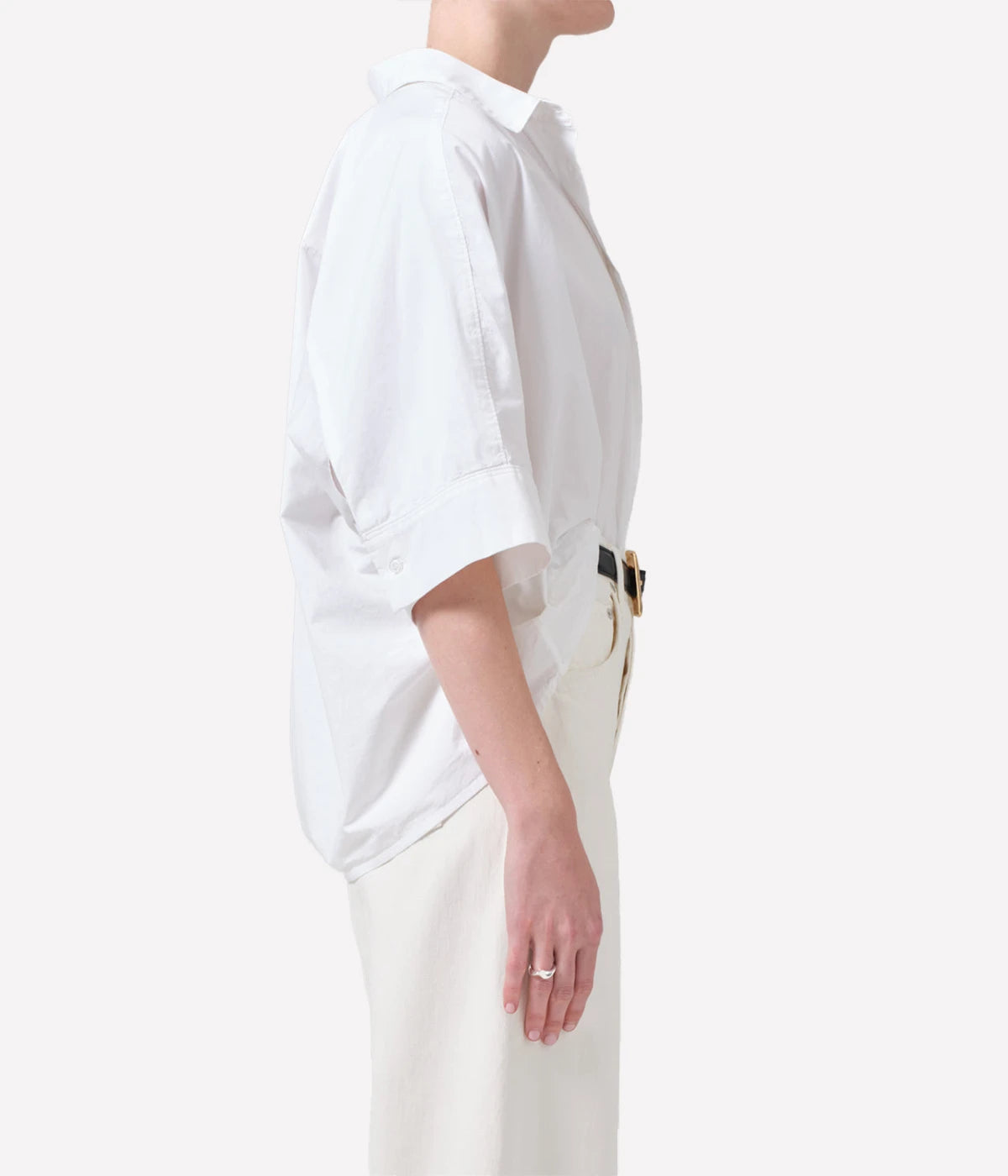 Oversized white cotton button-down shirt styled with relaxed trousers for a chic, casual outfit.