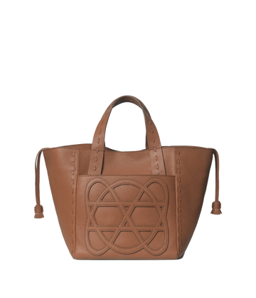 An everyday small tote bag in caramel, featuring 100% calf leather, logo patch on pocket,  weaved handles, removable adjustable shoulder strap, canvas lined, internal pocket, zip closure, woven hand stitch detail, tassel. Made in Greece, luxury leather, everyday work bag, mum bag throw on and go, Loewe inspired bag. 