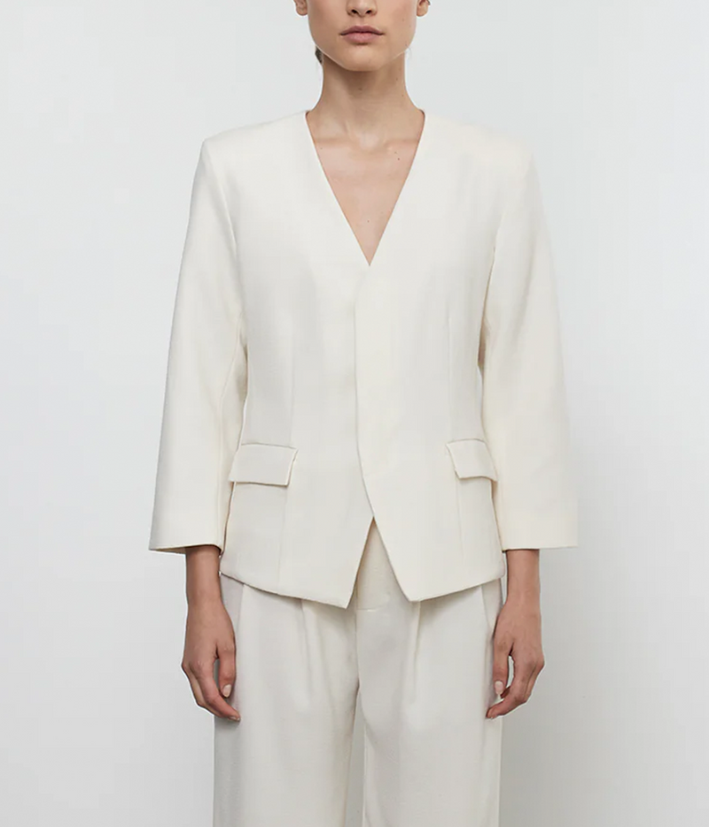 ALT text: Tailored cream crepe jacket with padded shoulders, concealed button placket, and smooth lining, styled for a polished, sophisticated look.