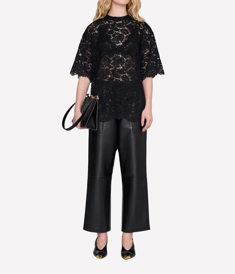 Model wearing the Anine Bing Zeina Top in Black Lace with black wide-leg trousers and heels, shown from the front.