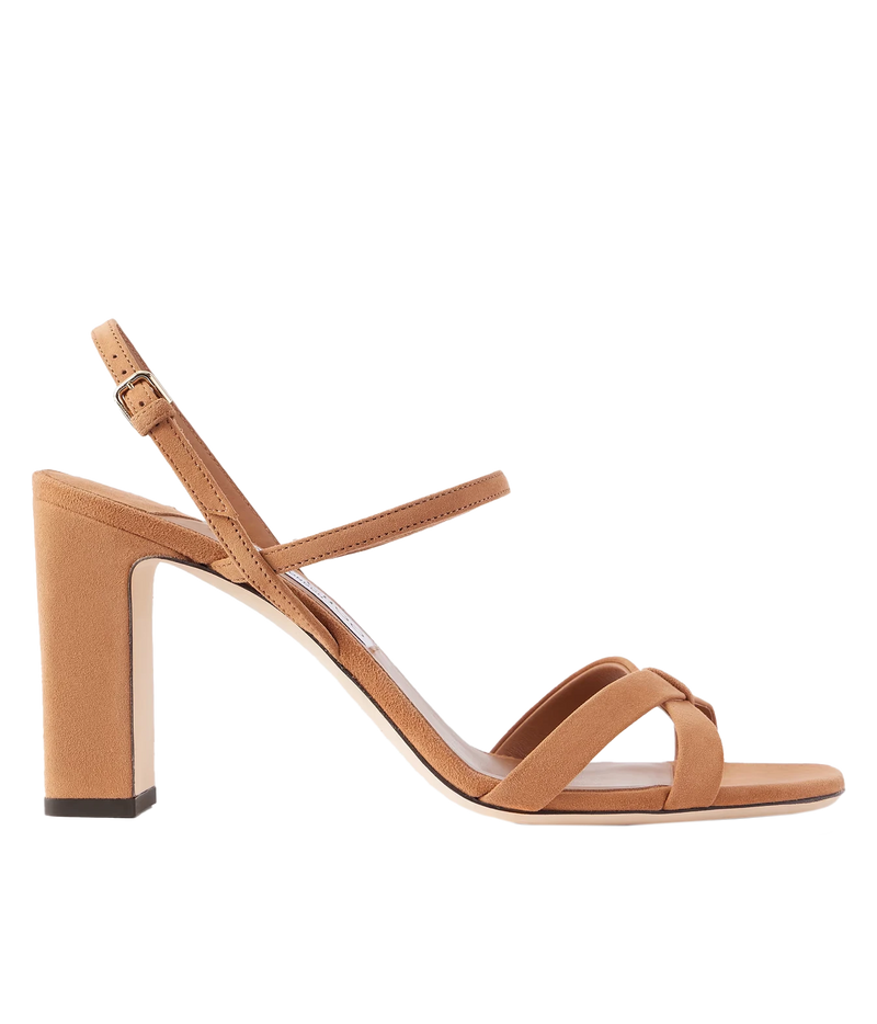 A tan block-heel sandal with a low block heel, a single ankle strap with a buckle, and two crisscrossing front straps, shown in profile against a white background.