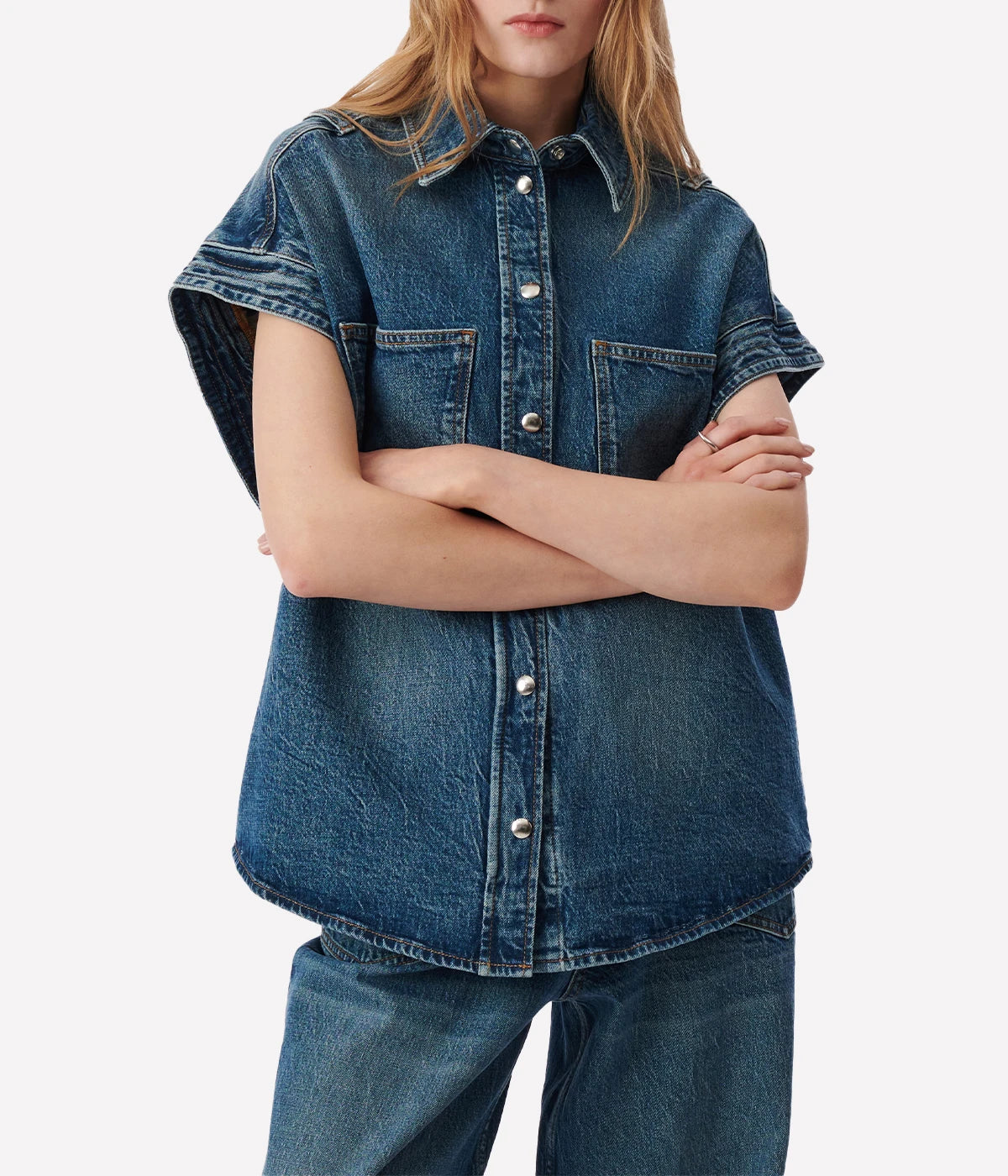 Elycia Denim Shirt in Denim Blue by IRO, sleeveless with a collar, breast pockets, and metal pop buttons, offering a relaxed fit in classic denim blue.