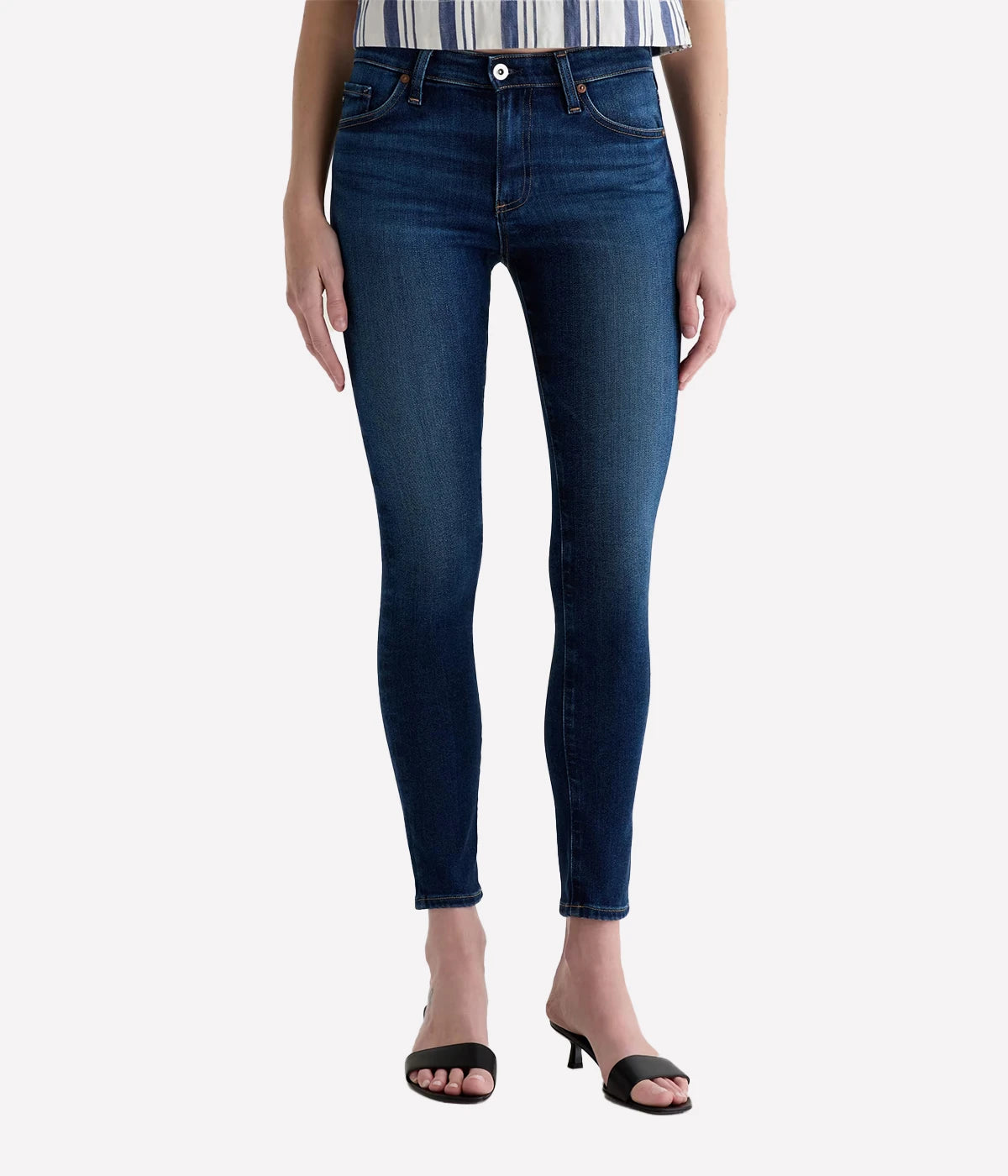 Person wearing dark blue jeans on a white background