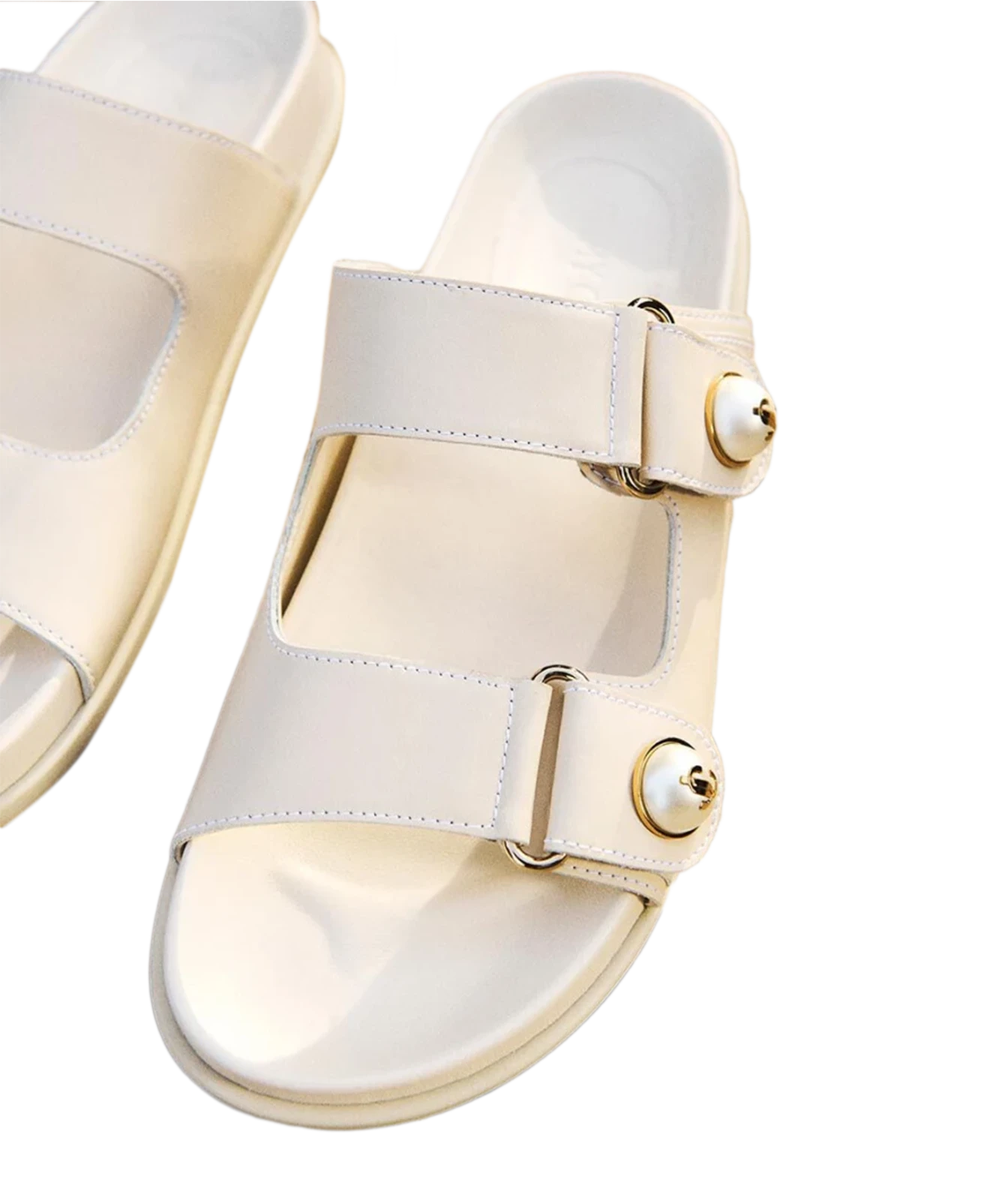 A pair of off-white double-strap slide sandals with gold-tone metal hardware and pearl-like decorative accents on the straps, shown on a clean white background.