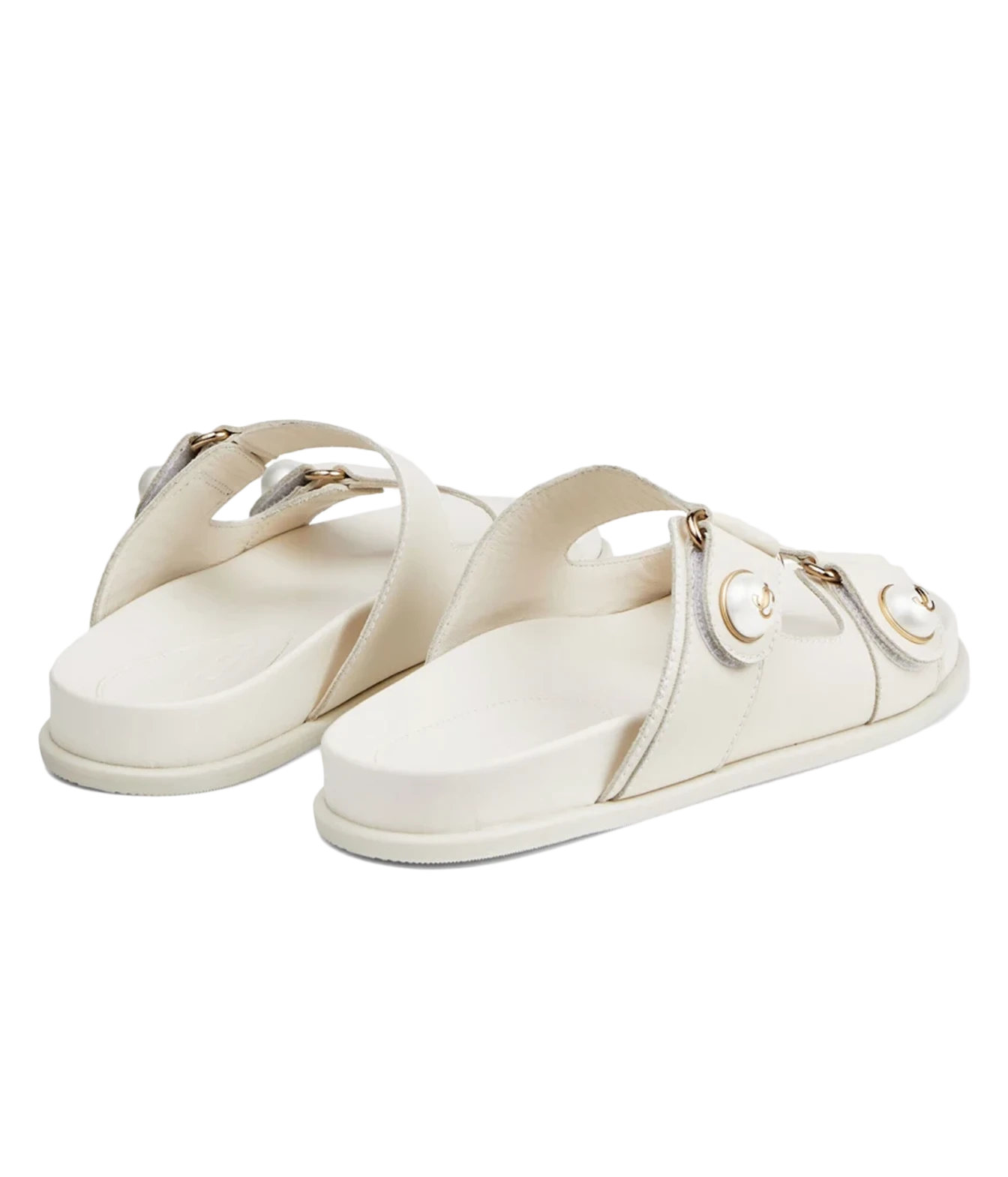 A pair of off-white leather slide sandals with double straps and gold-tone hardware, displayed on a clean white background.