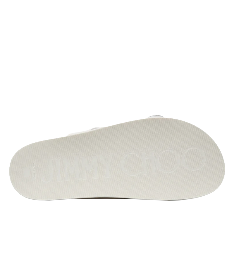 The bottom sole of a Jimmy Choo slide sandal, featuring the brand name 'JIMMY CHOO' embossed in a light tone on a white textured background.