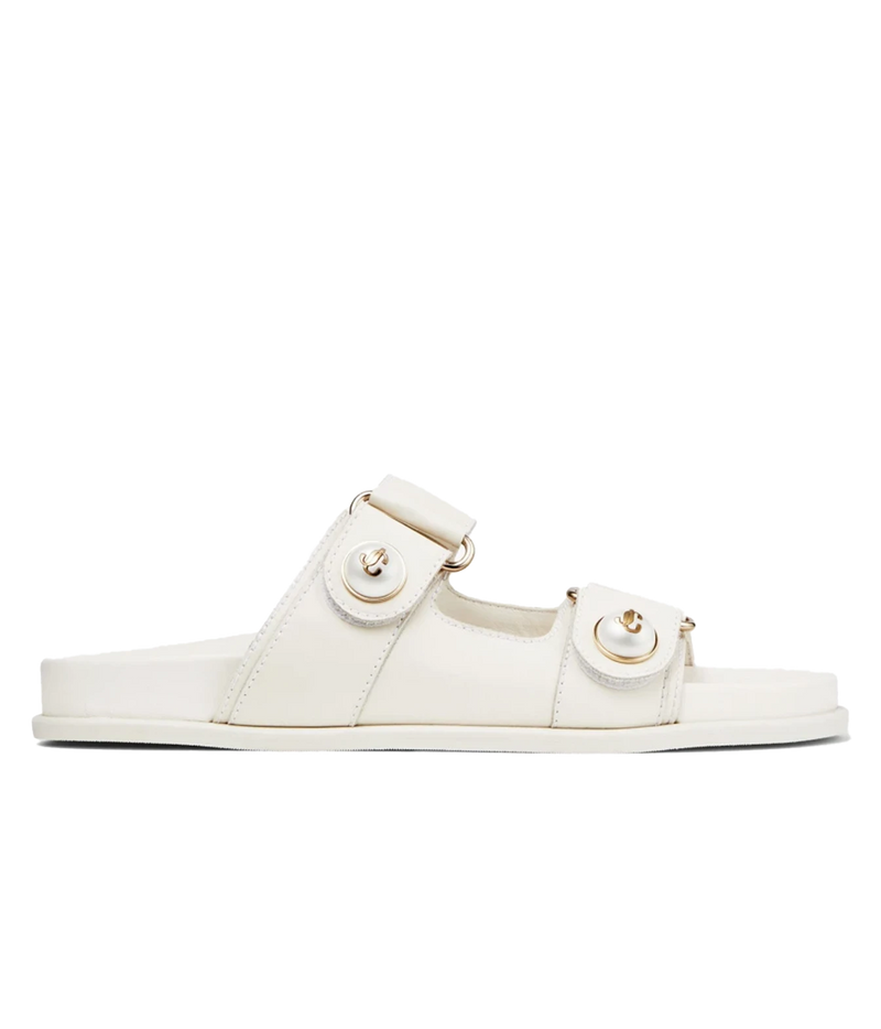 A single off-white leather slide sandal with two adjustable straps and circular gold-tone hardware, shown in a side profile on a solid white background.
