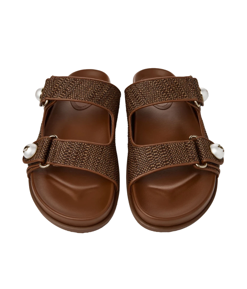 A pair of women's brown slide sandals with textured woven straps, adjustable buckles, and white decorative beads, shown from a top-down view on a white background.