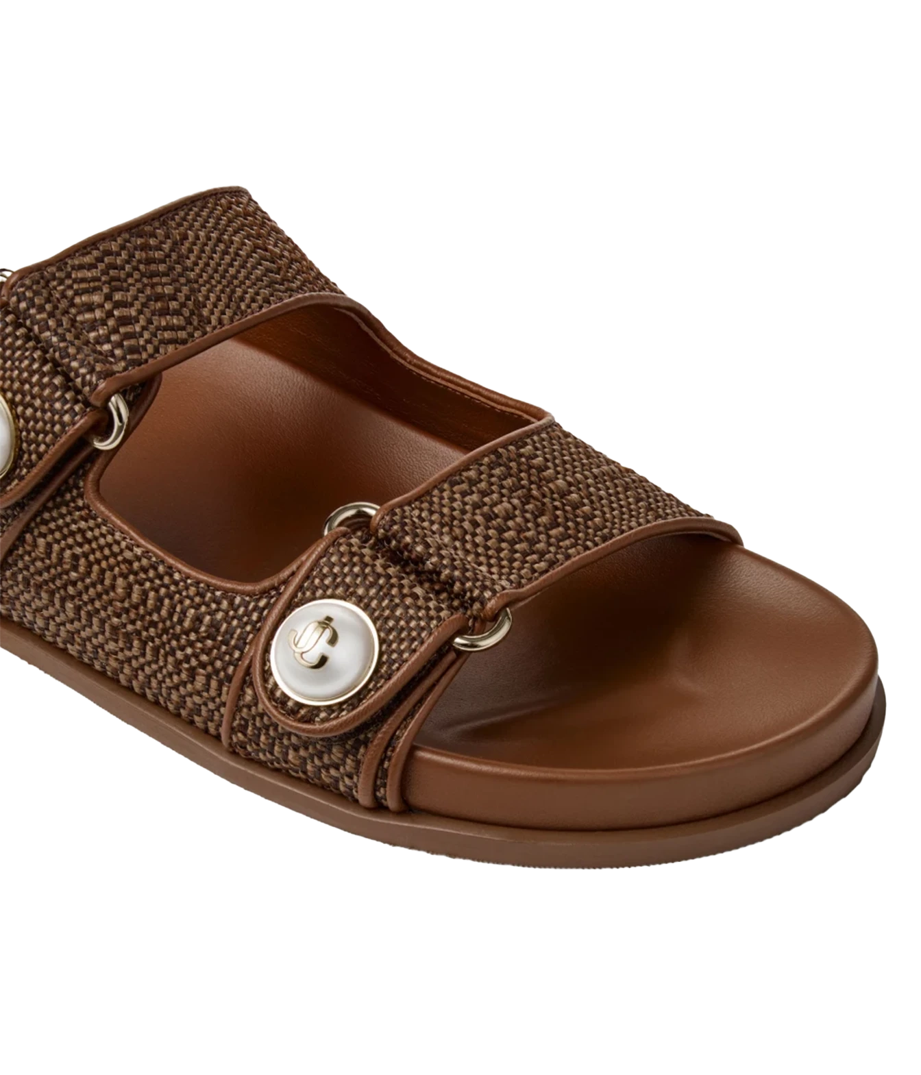 A brown slide sandal with a woven fabric strap and a large silver snap button, shown on a plain white background.