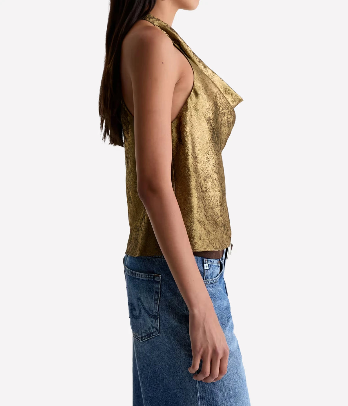 Side profile of a model wearing the AG Kacey Top in Wild Light with blue jeans, showing the halter cut and fluid drape