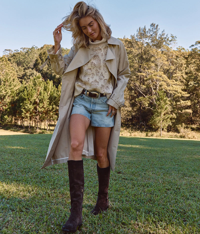 Avant Toi Hand Painted Leopard Jacquard Effect High Neck Pullover In Vaniglia, worn on model under an open trench coat with denim shorts, a brown belt and tall brown boots