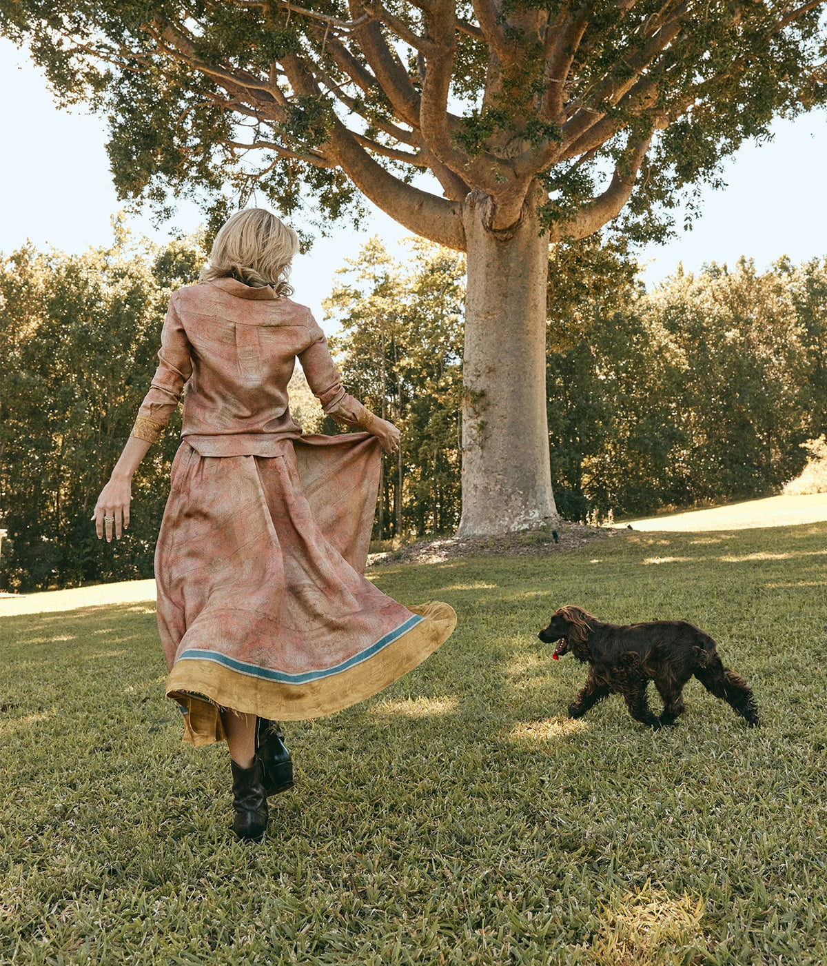 Pierre-Louis Mascia Aloe Silk Longsleeve Shirt in Terracotta Multi, worn on model with the matching Aloe Skirt and black boots, walking on a lawn with a spaniel