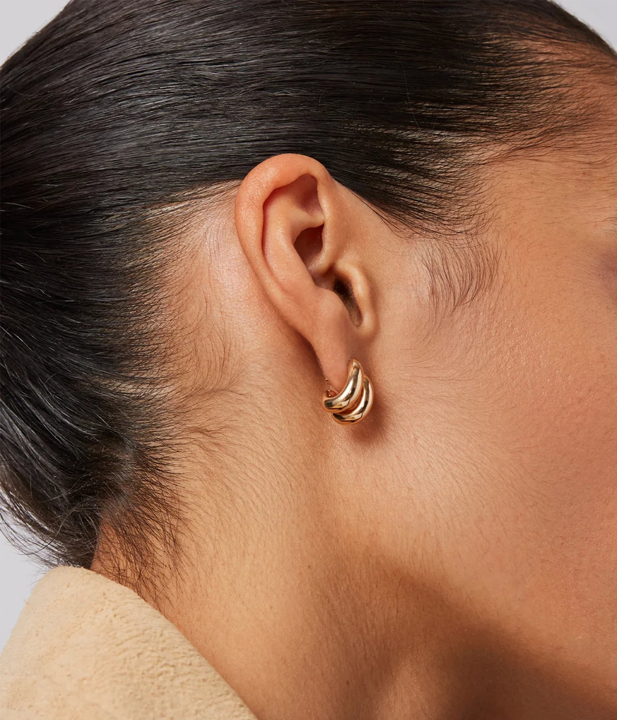 Side profile of a model with dark hair pulled back wearing the Jenny Bird Mini Florence Earrings in Gold