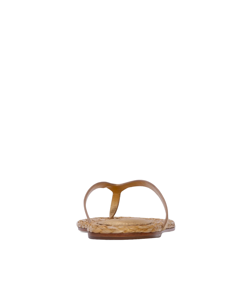 A single flat thong sandal with a gold leather strap and a woven natural straw footbed - Alaya Sandal in Gold Metallic