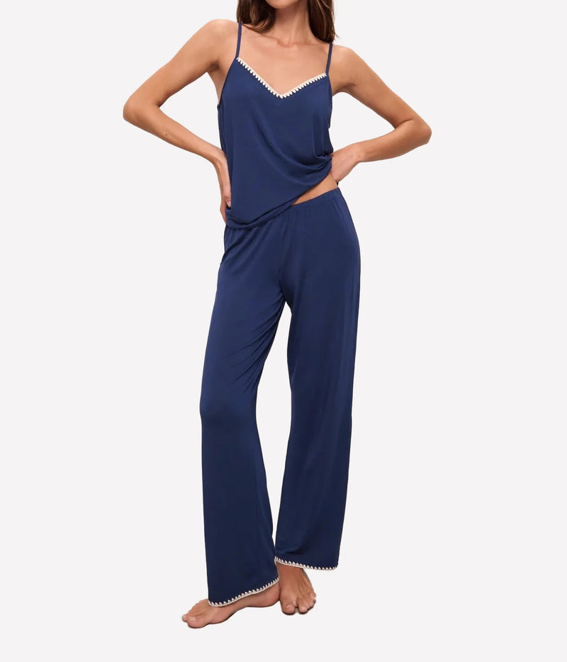 Model wearing the Eberjey Frida Cami Pant PJ Set In Navy & Ivory with hands on hips, front view showing the V-neck cami with ivory picot trim and fine straps, with full-length pants