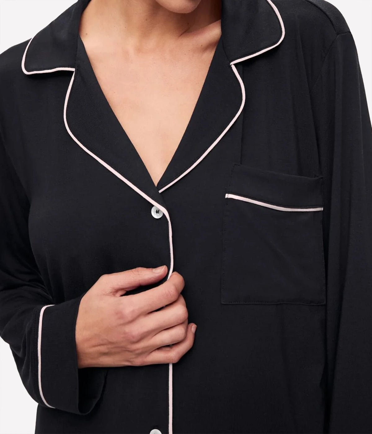 Close-up of the Eberjey Gisele Long Sleeve PJ Set in Black & Sorbet Pink showing the notch collar, piped chest pocket and buttons, with the model's hand at the placket