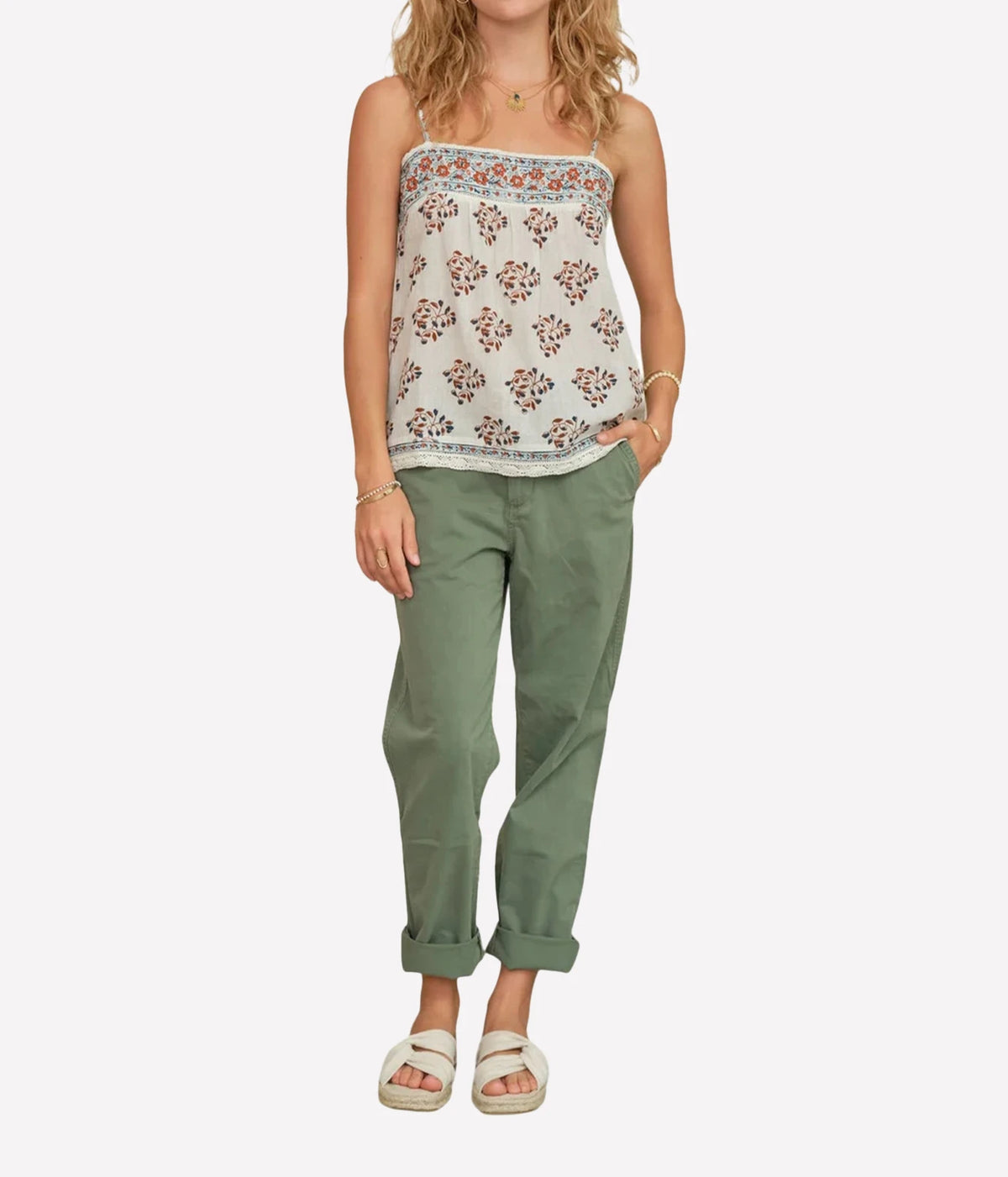 Woman wearing the M.A.B.E Stella print cami in Ecru & Rust with green trousers, full-length front view.