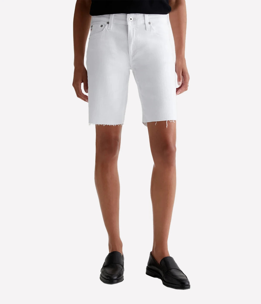 A longline white denim short for women with a raw hem by AG. Wash and wear for extra coverage.