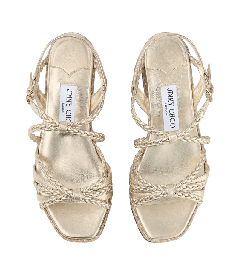 A pair of metallic gold strappy sandals by Jimmy Chono, featuring braided straps and a low block heel, shown from a top-down view on a white background.