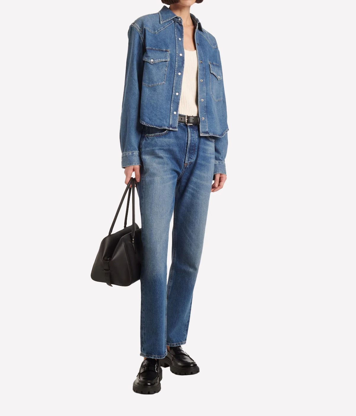Model wearing the Citizens Of Humanity Cropped Western Shirt in Chaya open over a cream singlet with mid-wash straight-leg jeans, a black belt, black leather handbag and black chunky loafers