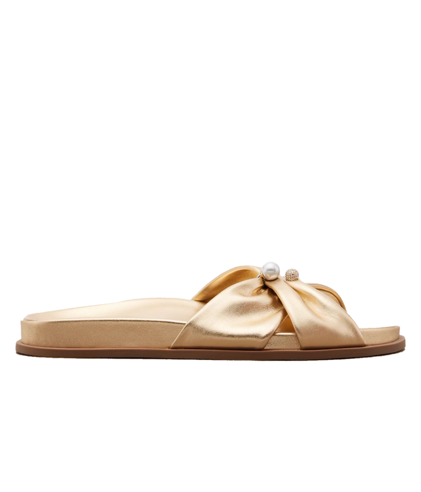 A single flat slide sandal in metallic gold satin, featuring a wide criss-cross bow design across the top adorned with a small white pearl and a tiny gold bead, shown against a plain white background.