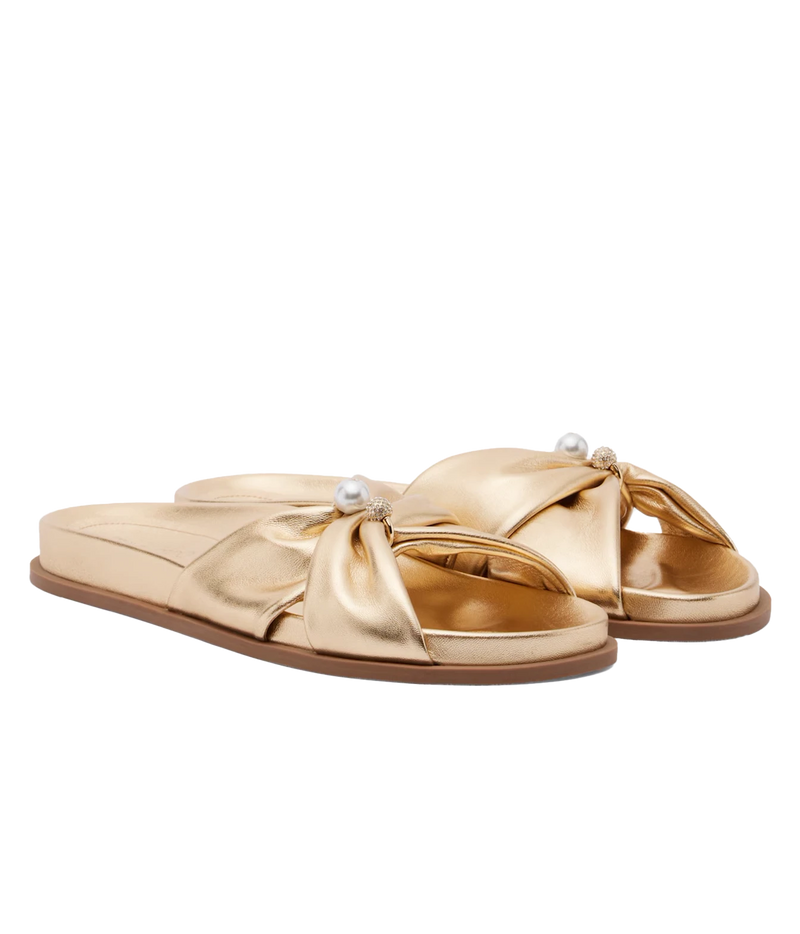 A pair of metallic gold slide sandals with wide crisscross straps, decorative pearl-like beads, and a flat brown sole, shown on a plain white background.