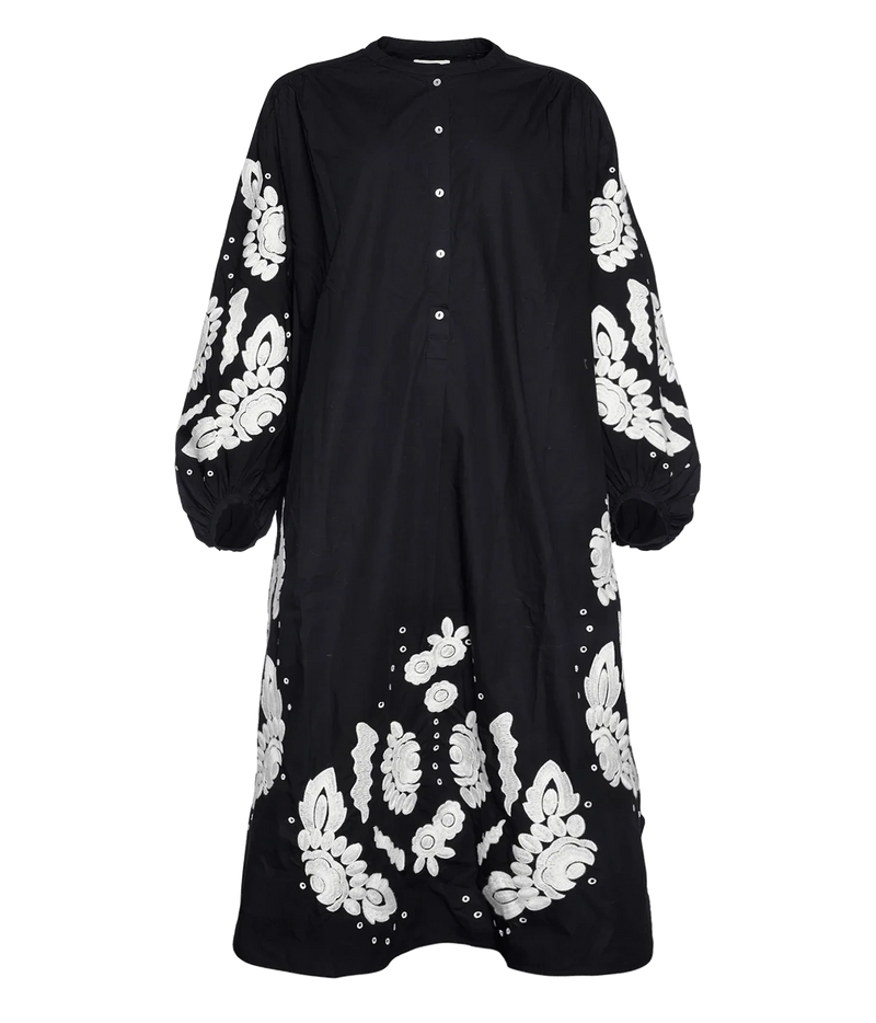 A black long-sleeve maxi dress with white floral embroidery on the sleeves and hem, featuring a button-up front and a round neckline, shown against a plain white background.