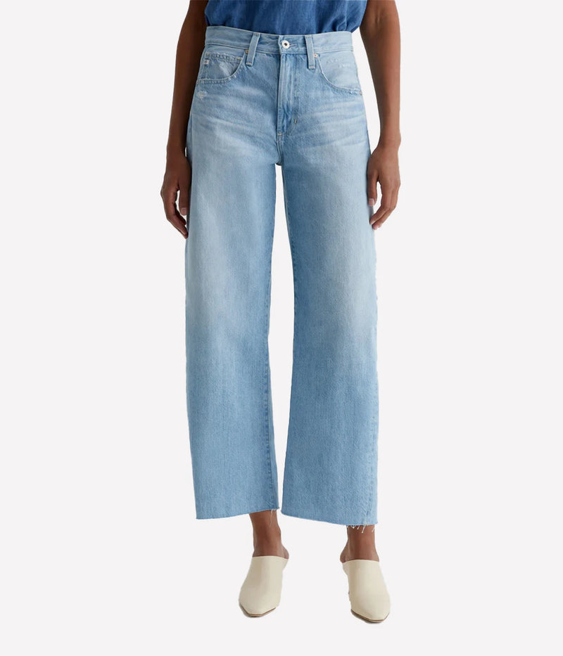 ALT text: Model wears mid-rise cotton denim jeans with fading, whiskering, and light distressing throughout