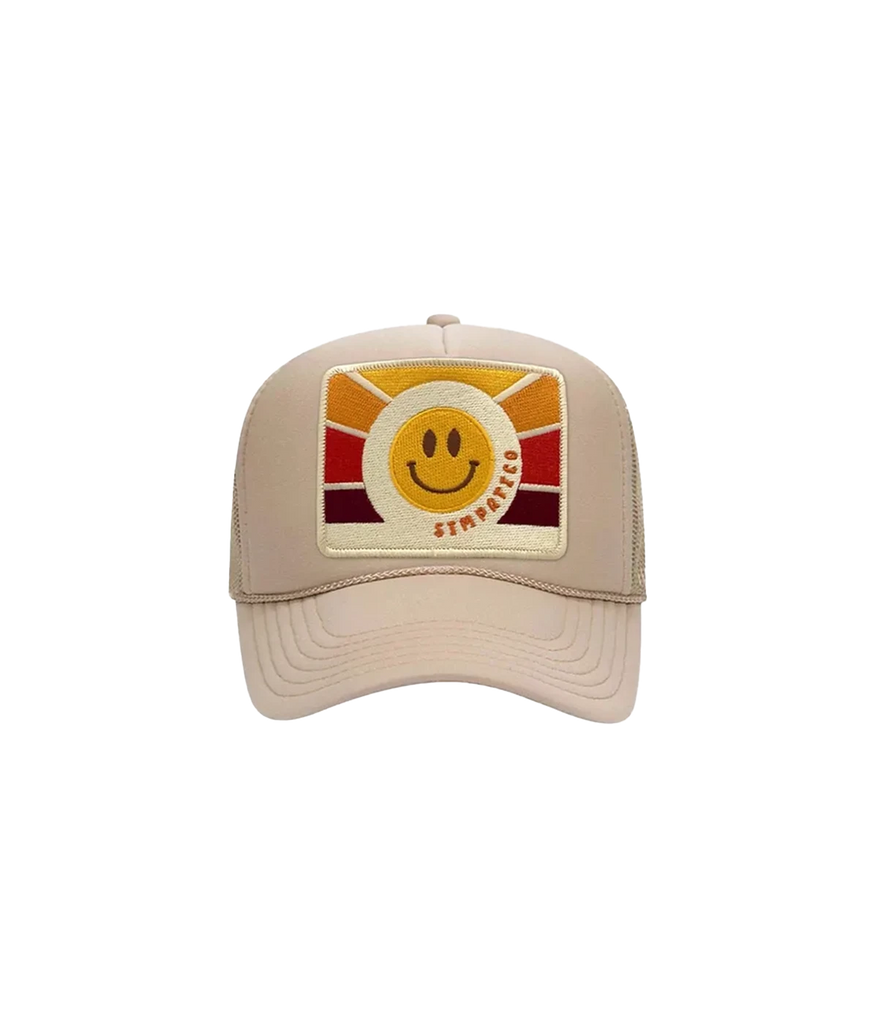 A statement trucker hat in a neutral beige colourway, featuring a red, orange and yellow sunrise style smile face and sympatico written  text, curved brim hat and netted back. Statement hat, throw on and go, easy to wear, summer staple, made internationally. 