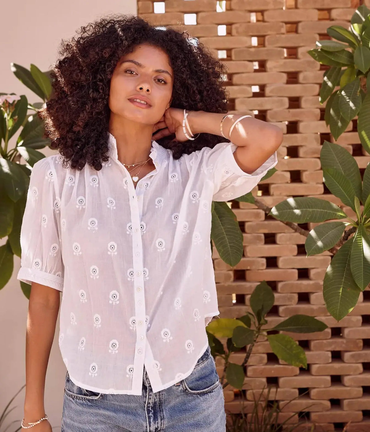 Model wearing the M.A.B.E Frani Embroidered Short Sleeve Top in White with blue jeans